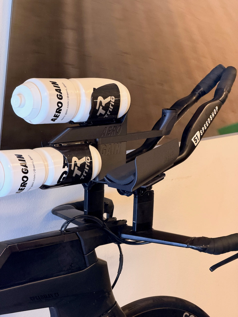 Close-up of the AeroGain Aero BTA system on a Canyon Speedmax CF, with two bottles stacked between the arm cups