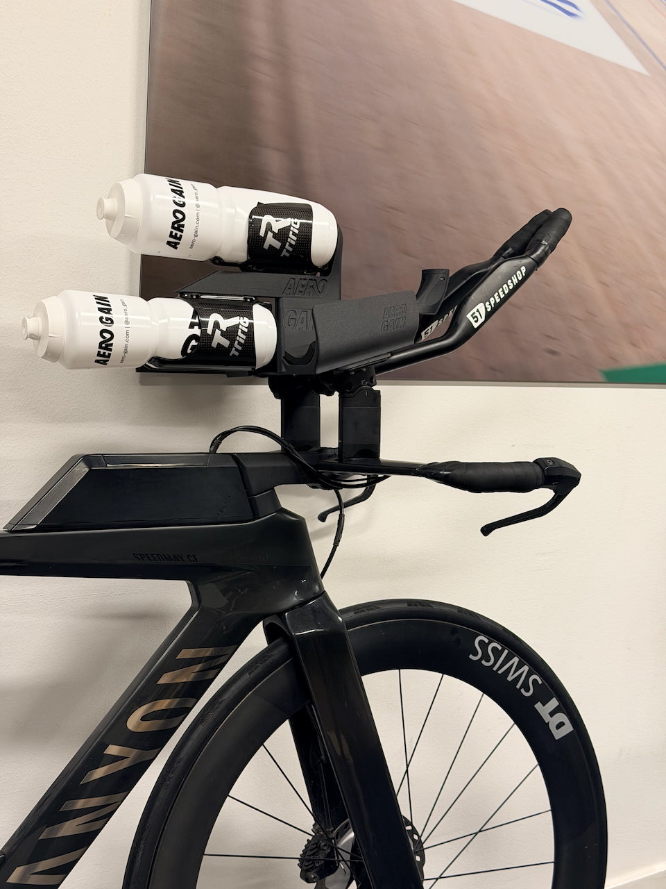 Canyon Speedmax CF with the AeroGain Aero BTA system on the carbon mount plate, two AeroGain bottles held between the extensions